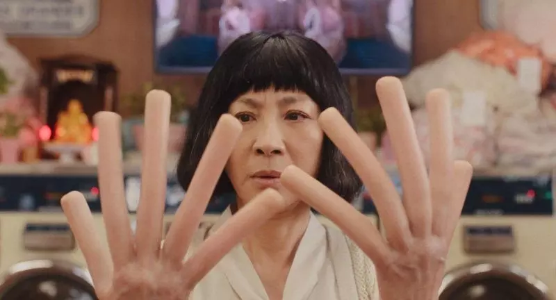 《媽的多重宇宙》好看嗎?遲到的觀影心得:劇情解析與結局後勁,獻給每個曾感到迷惘的你 10 《媽的多重宇宙》的電影劇照,主角王秀蓮(楊紫瓊 飾)的雙手變成了軟爛的熱狗,她正驚訝地看著自己的熱狗手指。