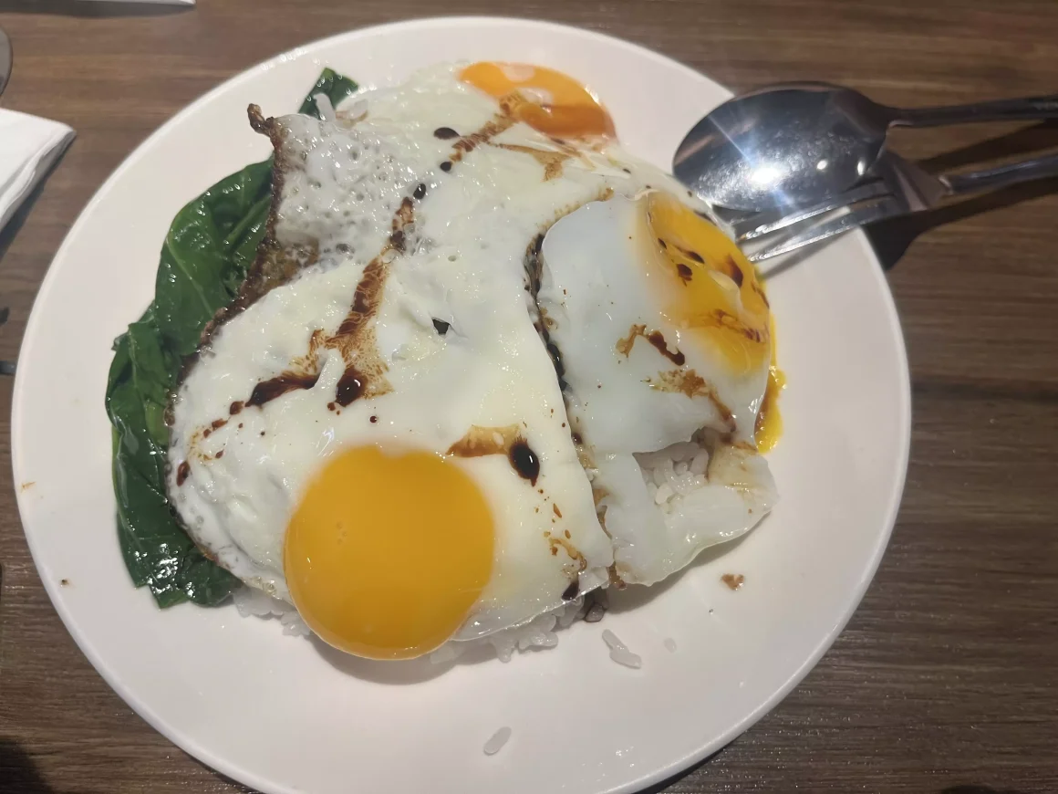 【板橋】《茗香園冰室》心得:當邪惡三眼仔遇上被遺忘的叻沙 10 茗香園冰室的招牌菜「邪惡三眼仔沙茶牛肉飯」,白飯上覆蓋著三顆半熟的太陽蛋和翠綠的青菜,並淋上了醬汁。