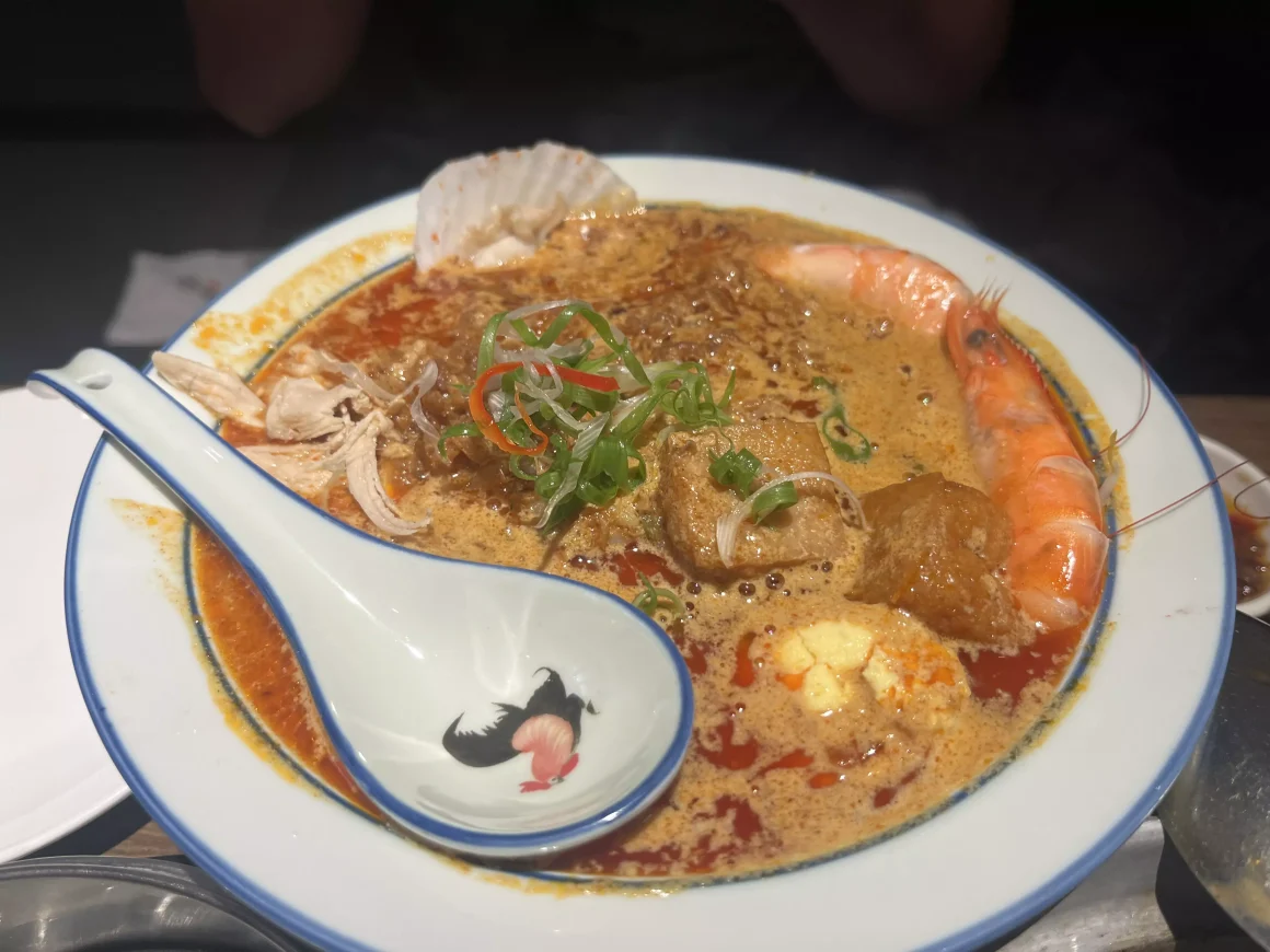 【板橋】《茗香園冰室》心得:當邪惡三眼仔遇上被遺忘的叻沙 14 茗香園冰室的娘惹海鮮樂叻沙米線,碗裡有鮮蝦、扇貝、油豆腐、雞絲和水煮蛋,湯頭呈現橘紅色。