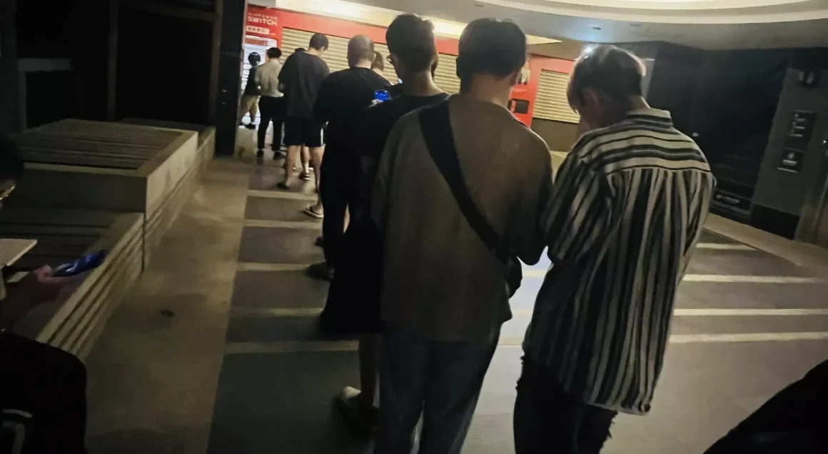 《寶可夢傳說 Z-A》推?不推?一個衝動,意外撞進一場瑕不掩瑜的派對 17 一群人在夜晚的遊戲店門口排隊,光線昏暗,他們正等待著購買《寶可夢傳說Z-A》的首發遊戲。