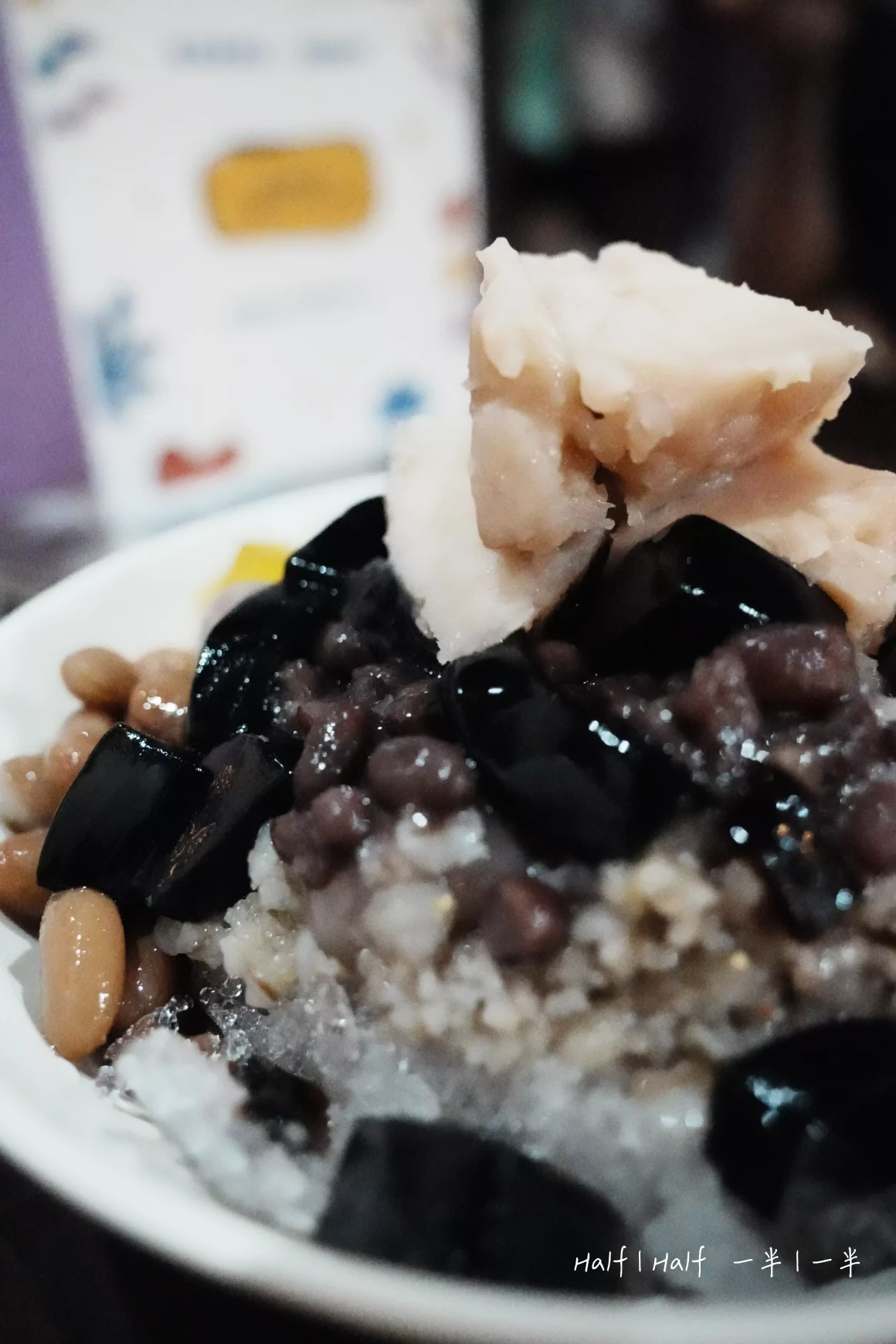 【土城】《芋頭之家》評價:一半是熱鬧的配料派對,另一半是C位出道的神級芋頭 12 「土城芋頭之家」芋頭冰的側面特寫,鏡頭聚焦在晶瑩的剉冰與上方的芋泥、仙草和紅豆,呈現出冰涼消暑的質感。